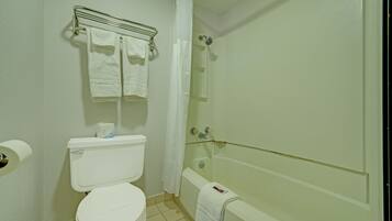 A bathroom with a toilet, a bathtub, and a shower curtain.