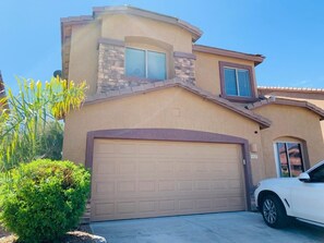 A residential house with a garage, a car parked in front, and a clear sky. - Spacious 5-bedroom house in gorgeous Tucson with AC (Tucson)