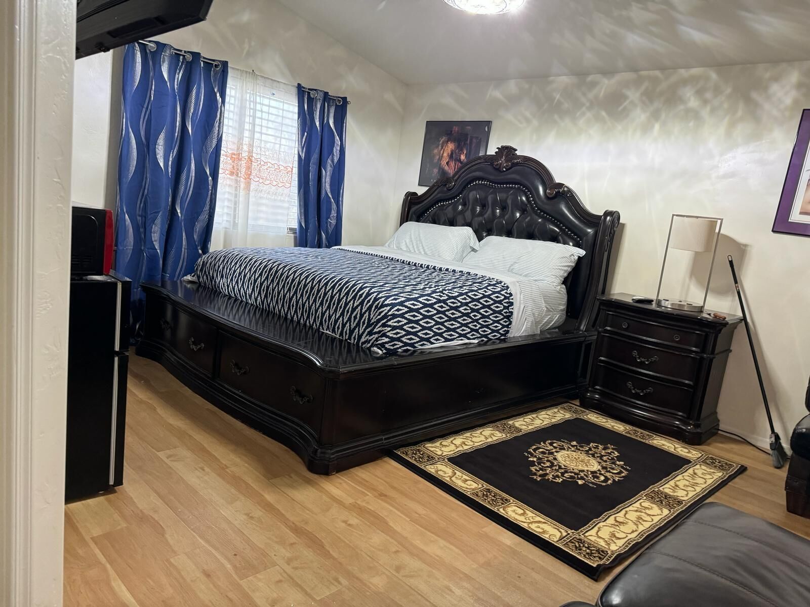 A bedroom with a bed, bedside tables, a rug, and a picture on the wall.
