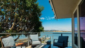 A balcony with a view of the sea, furnished with two chairs and a table. - Eria events and stay on Paradise, premier modern waterfront retreat (Corte Madera)