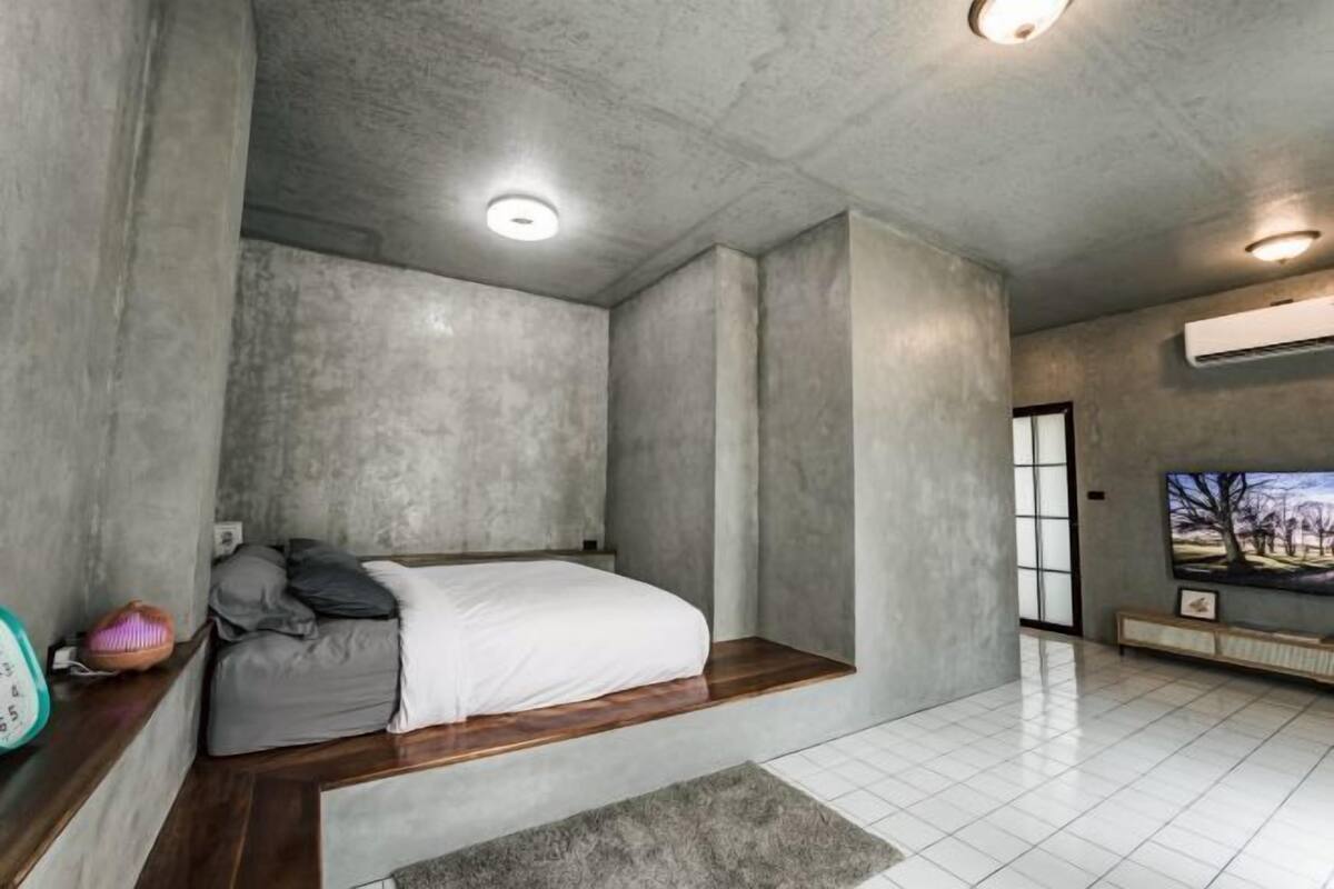 Une chambre à coucher avec un lit, une télévision et une fenêtre.