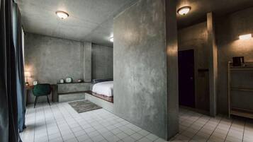 A modern bedroom with a bed, bedside tables, and a nightstand.