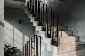 Un escalier avec des rampes en métal et un mur en béton.