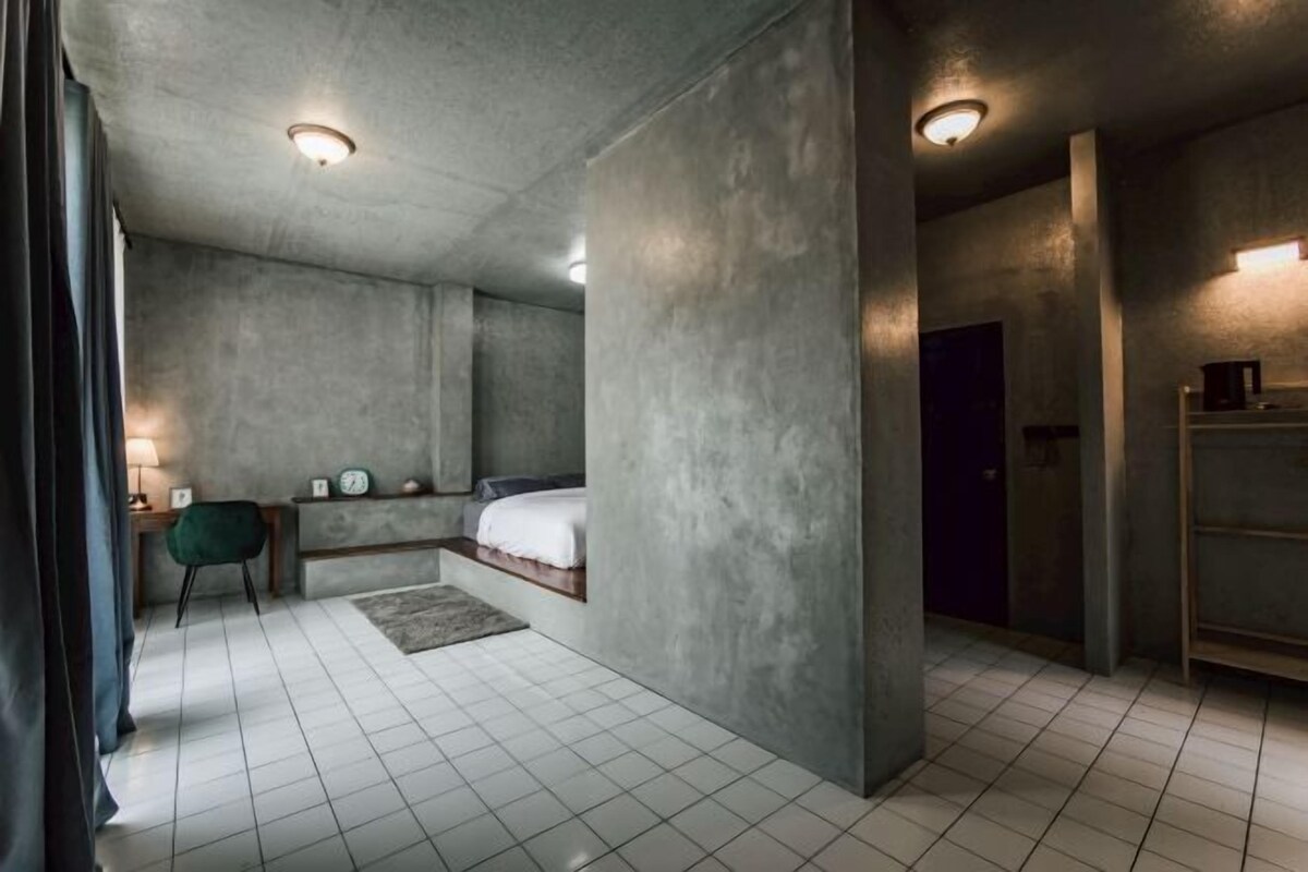 Une chambre à coucher moderne, comprenant un lit, des tables de chevet, une chaise et une armoire.