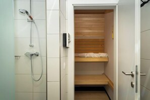 A small, compact bathroom with a shower, a wooden shelf, and a door. - Luxescape-Chalet Apartement Almzeit-Wandern-Traumaussicht-Sauna-Naturschutzgebiet (Predlitz-Turrach)
