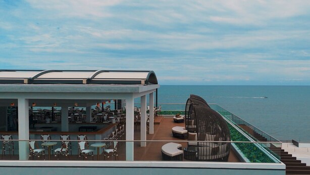 Een terras op het dak met buiten zitplaatsen, een zwembad en uitzicht op zee.