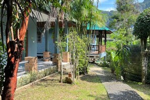 A pathway leading to a building with a covered porch and a view of a mountainous landscape. - Moubillow Resort (Krabi)