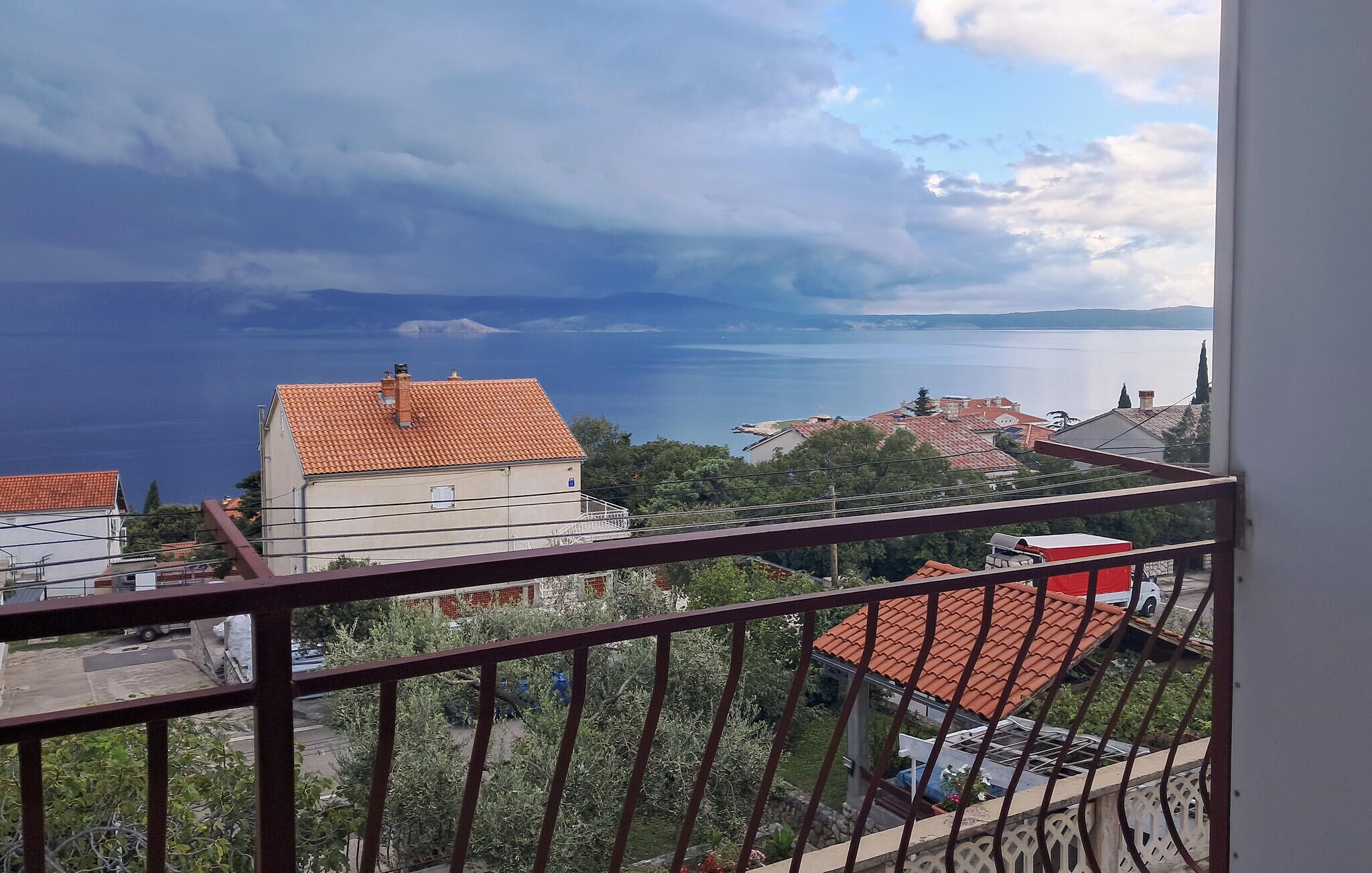 Ein Balkon mit Blick auf einen See und Gebäude.