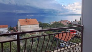 Ein Balkon mit Blick auf einen See und Gebäude.