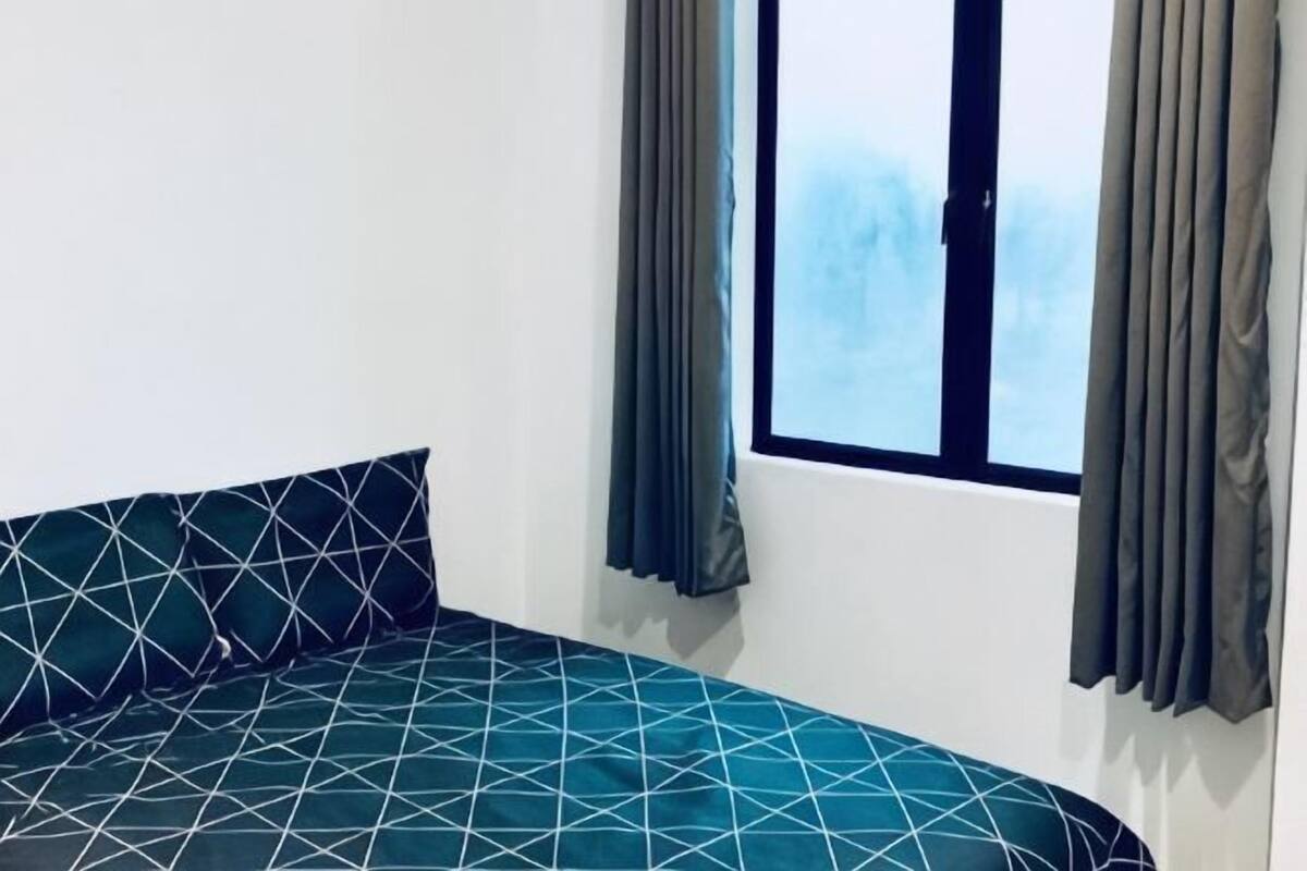 Ein Zimmer mit einem Bett, einem Vorhangfenster und Blick zum Himmel.