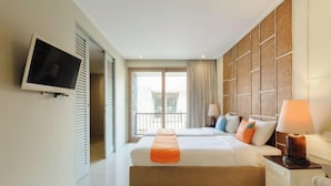 A hotel room with two beds, a TV, a balcony, and a view of the city. - Sans Vibes Astana Residence Seminyak (Bali)