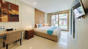 A modern hotel room with a bed, desk, and a large window. - Sans Vibes Astana Residence Seminyak (Bali)