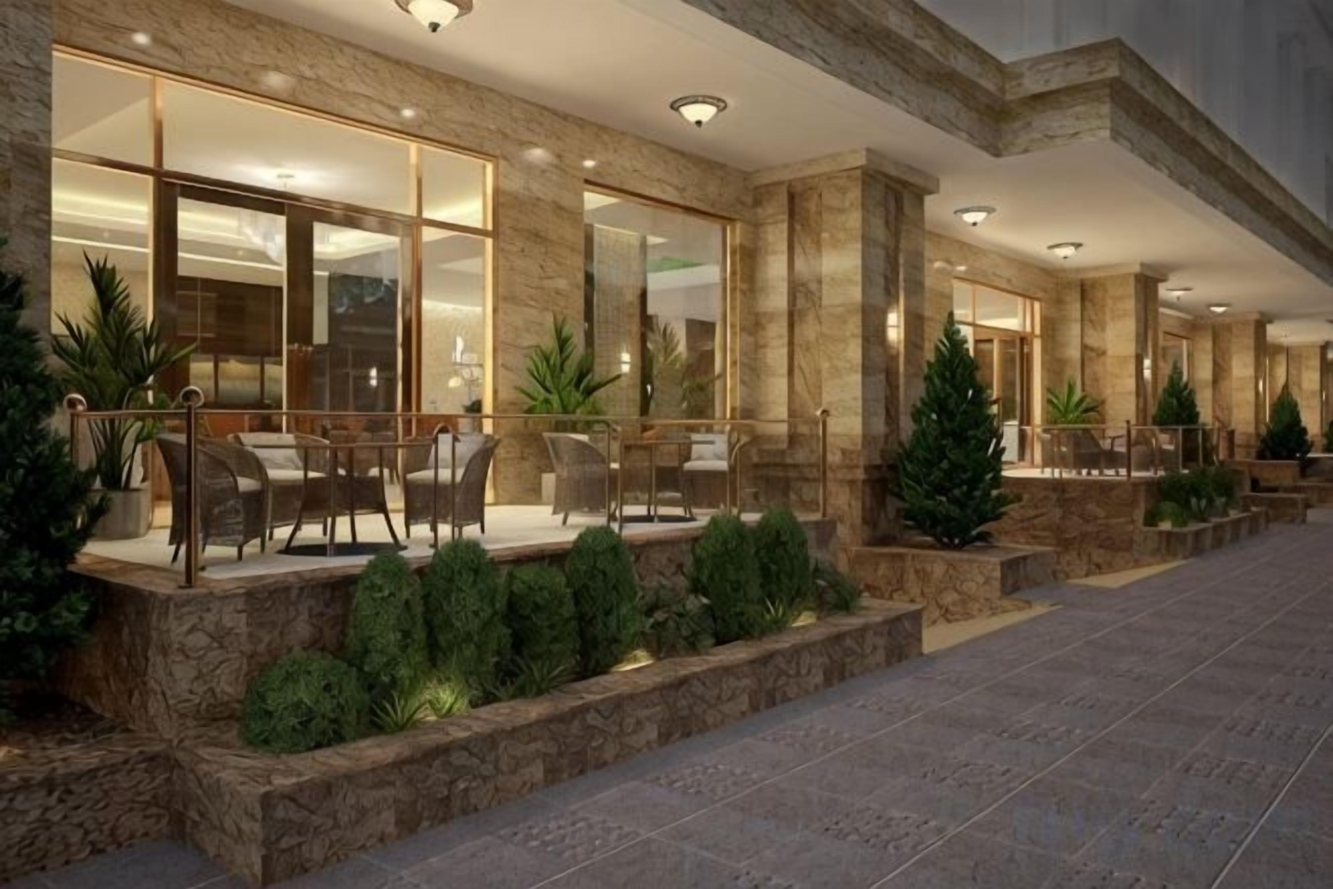 A hotel lobby with a seating area, a reception desk, and a large window.