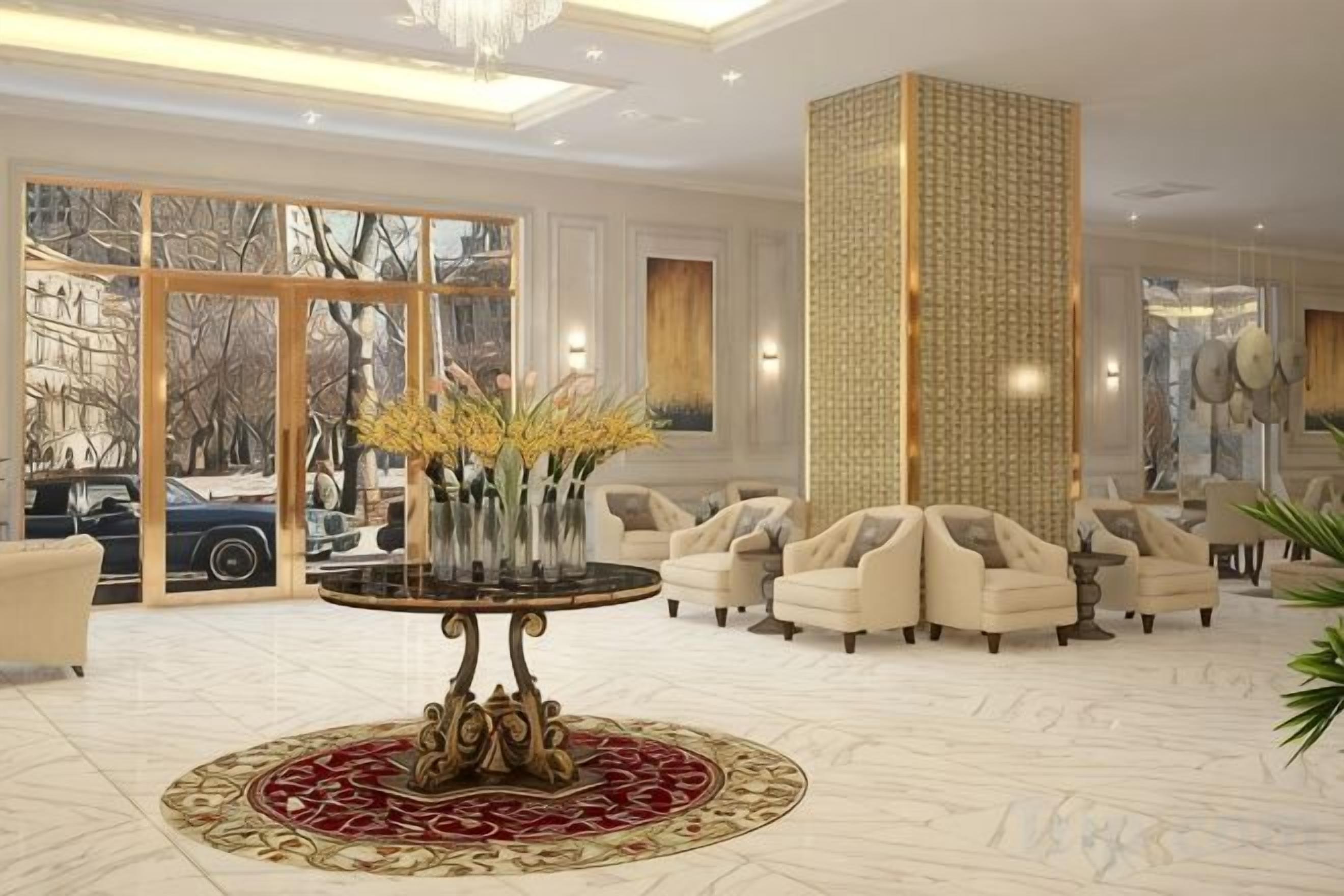 A spacious lobby with a round table, seating area, and large windows.