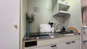 A compact kitchen with a microwave, sink, and cabinets. - 3 Guests Kitchen & Washer 7-min Walk to Waseda University (Tokyo)