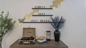 A wall with decorative hexagonal patterns and a sign that reads "SIMPLY KOZY JUST RELAX".