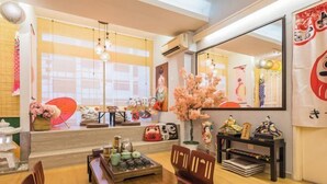 A room with a dining table, chairs, a mirror, and decorative items. - Fahrenheit88-Ancient Loft House ( Japan Theme ) (Kuala Lumpur)