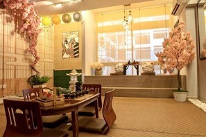 Un área de comedor tradicional japonesa con esteras de tatami, una mesa baja y sillas de madera.