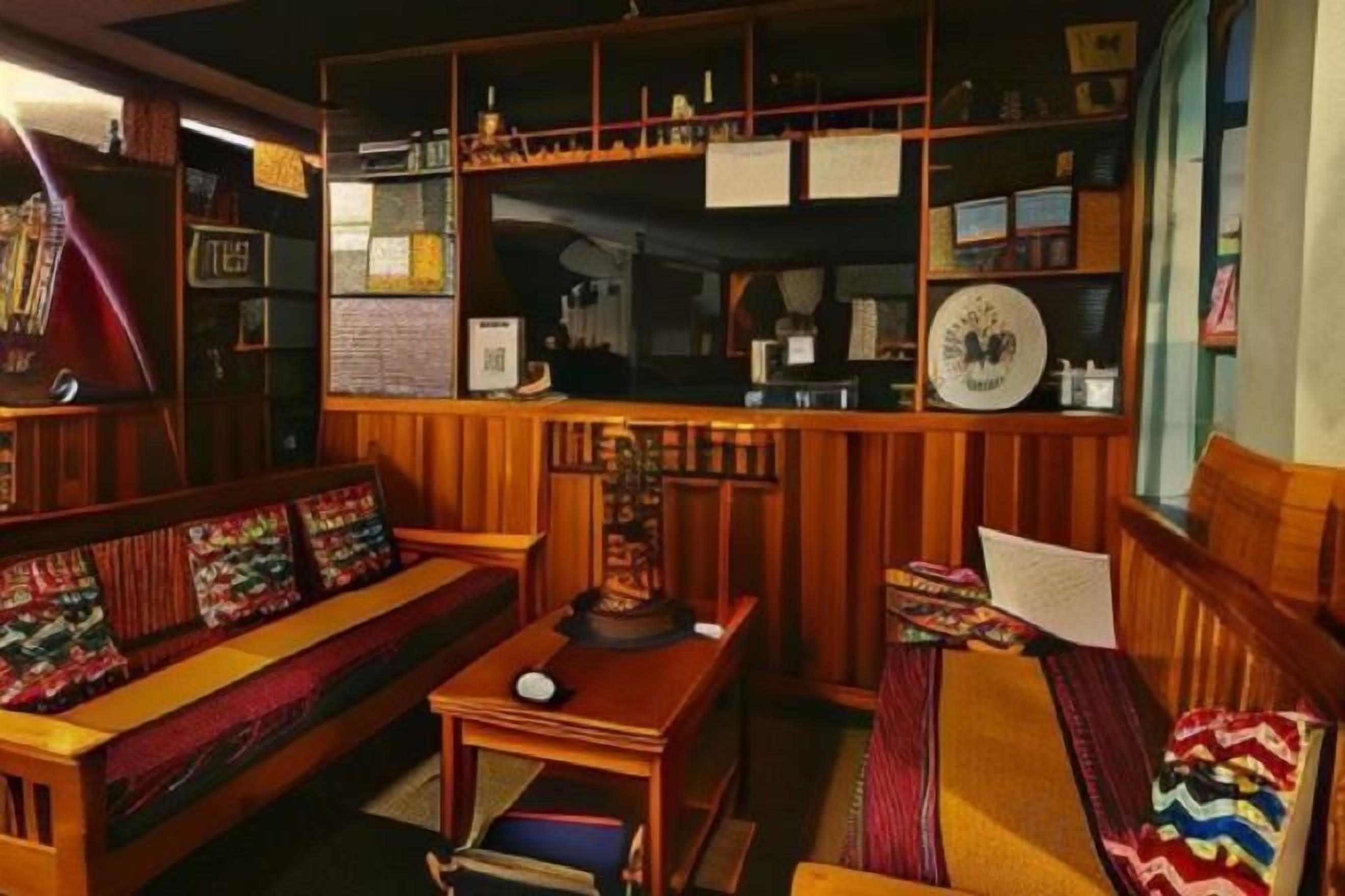 A cozy room with a wooden sofa, a small table, and shelves with various items.