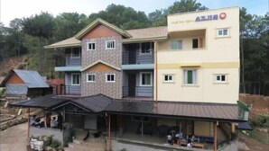 Un edificio a più piani con tetto piatto e un'area esterna coperta con posti a sedere.