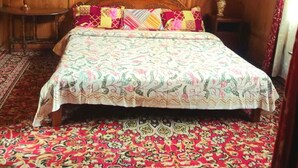 Una habitación de madera con una cama, una lámpara y una mesita.