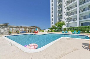 Una piscina al aire libre, sillones reclinables de piscina