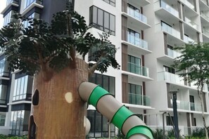 A modern building with balconies and a tree with a green and white structure attached to it. - Garden Home at Midhills Genting Highlands Free WiFi (Genting Highlands)