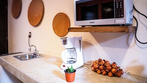 A kitchen with a sink, a coffee maker, a microwave, and a potted plant. - Hotel Boutique Cielito Lindo (Jilotepec)