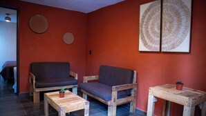 A room with two sofas, a small table, and a wall-mounted artwork. - Hotel Boutique Cielito Lindo (Jilotepec)
