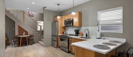 A modern kitchen with wooden cabinets, stainless steel appliances, and a central island.