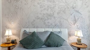 A bedroom with a bed, two nightstands, and wall art. - SF Coast Work/Play/Hike + HotTub (Daly City)