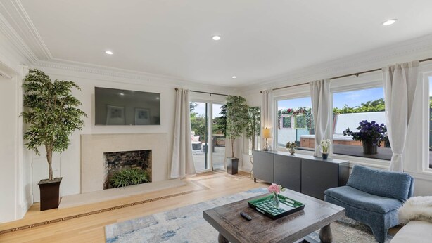 A spacious living room with a fireplace, large windows, and a blue rug. - SF Coast Work/Play/Hike + HotTub (Daly City)