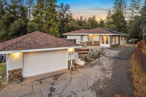 A two-story house with a garage, a driveway, and a well-maintained lawn.
