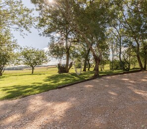 A gravel path leading to a grassy area with trees and a hammock. - Castel Ginest - LAHAGE (LAHAGE)