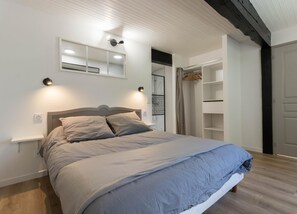A bedroom with a bed, bedside tables, a wardrobe, and a door. - Castel Ginest - LAHAGE (LAHAGE)