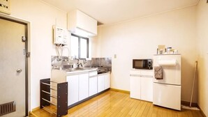 A compact kitchen with a microwave, refrigerator, and sink.