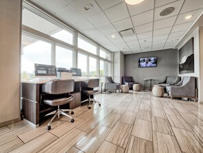 A modern hotel lobby with a reception desk, several seating areas, a large window, and a mounted television. - Candlewood Suites Tacoma Mall by IHG (Tacoma)
