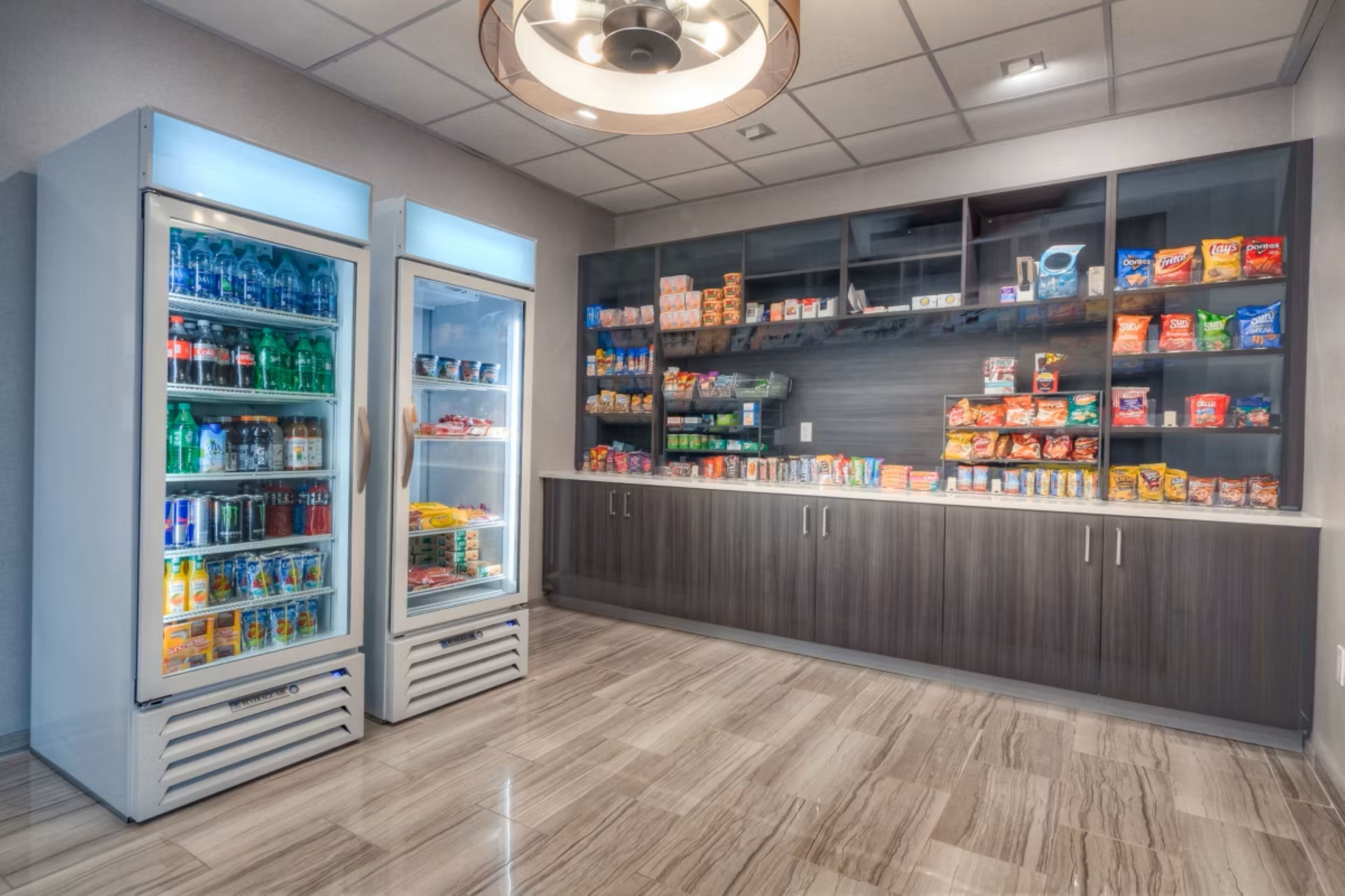 Una cocina moderna con dos dispensadores de bebidas, una despensa llena de aperitivos y un piso de baldosas impecable.