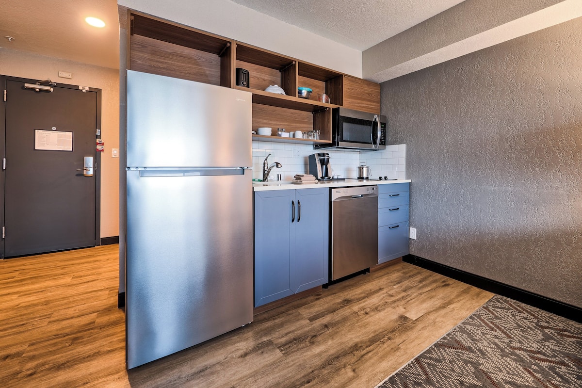 A compact kitchen with a stainless steel refrigerator, a microwave, and a dishwasher.