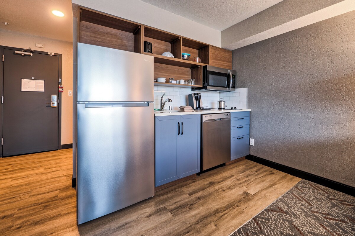 A compact kitchen with a stainless steel refrigerator, a microwave, and a dishwasher.