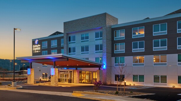 A hotel with a modern design, featuring a covered entrance, multiple floors, and a prominent sign.