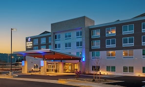 A hotel with a modern design, featuring a covered entrance, multiple floors, and a prominent sign.