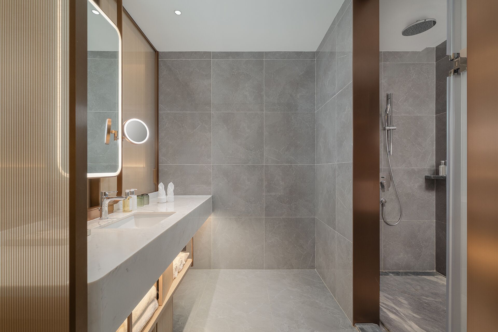 A modern bathroom with a vanity, mirror, and shower.
