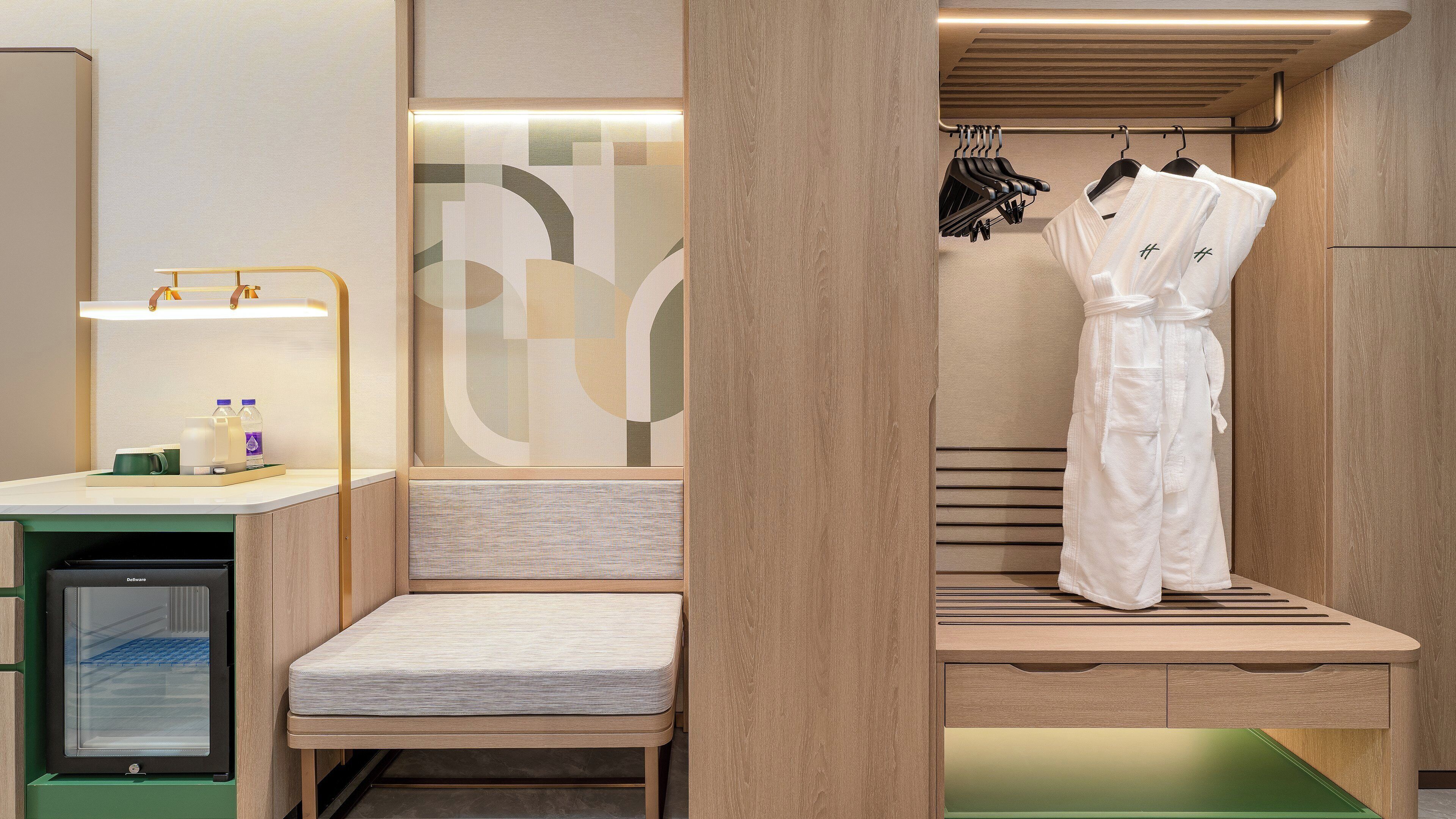 A modern bathroom with a wooden vanity, a shower area, and a hanging robe.