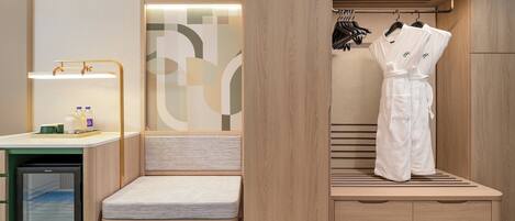 A modern bathroom with a wooden vanity, a shower area, and a hanging robe.