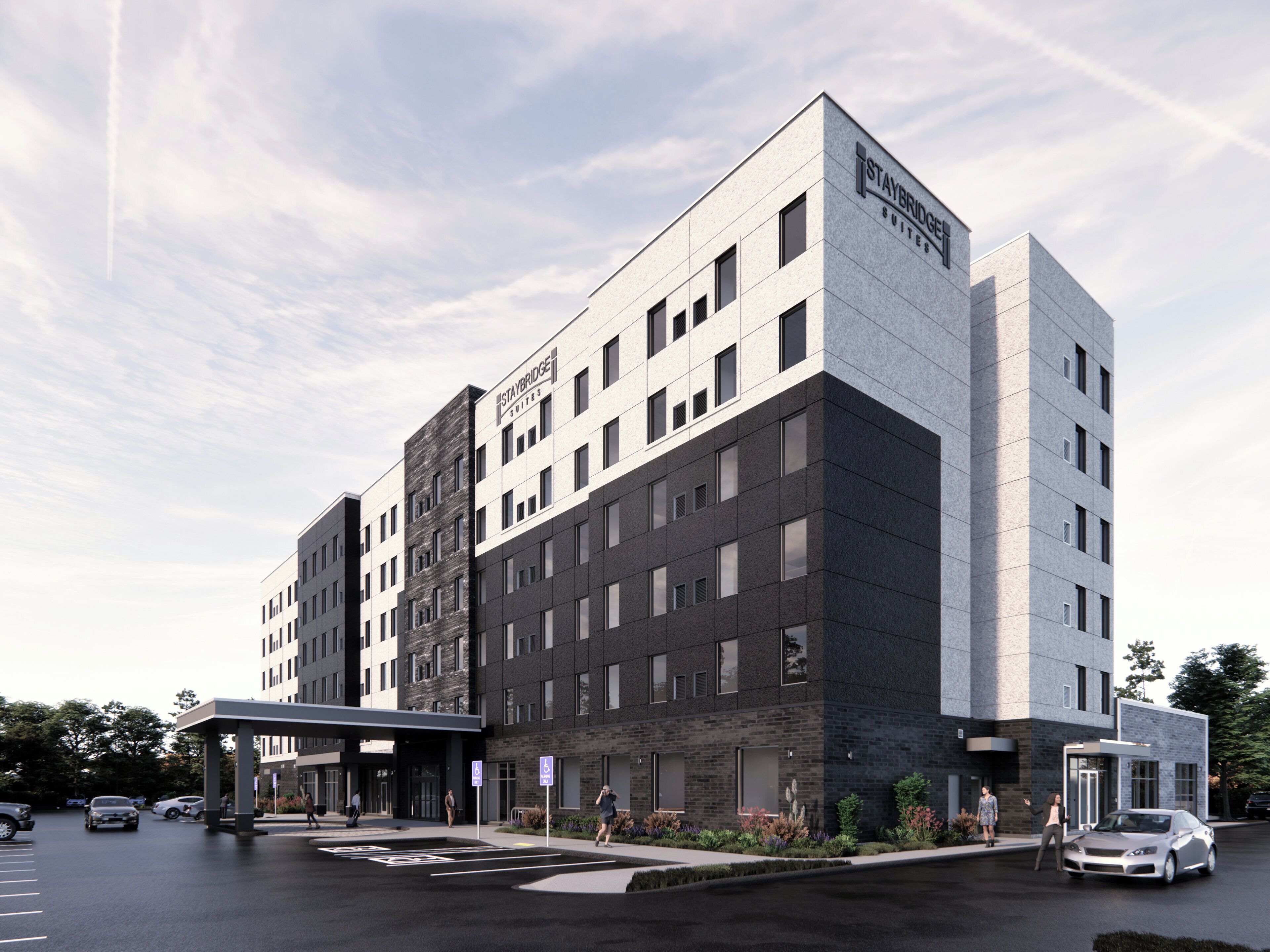 A modern hotel with a flat roof, multiple floors, and a prominent Staybridge Suites sign.