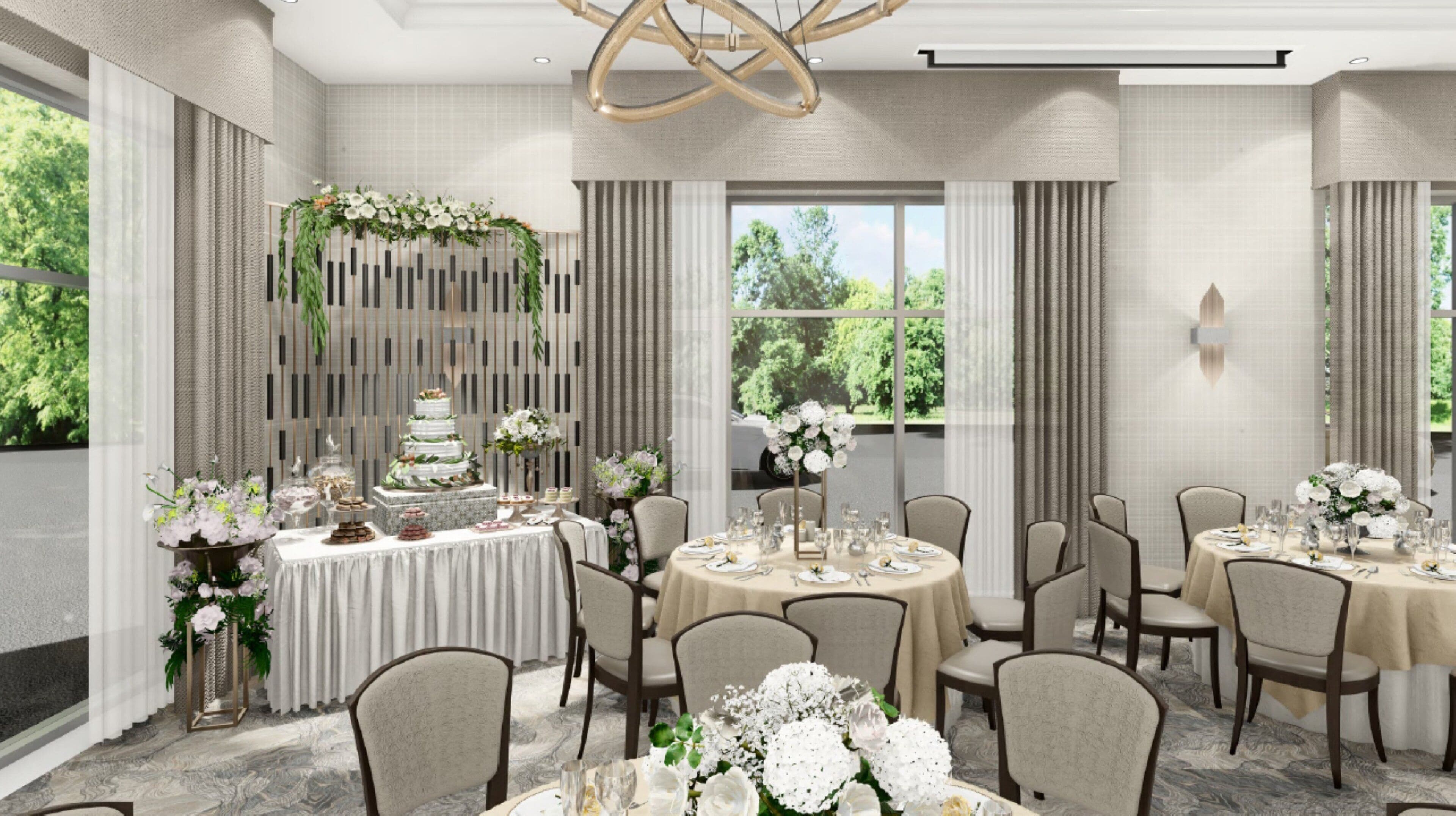 A spacious banquet hall with round tables, elegant floral arrangements, and a tiered wedding cake centerpiece.