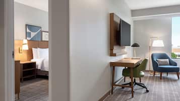 Hotelkamer met een bed, bureau, stoel, televisie en raam met uitzicht.