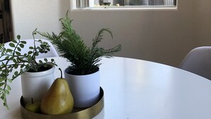A white table with three potted plants and two pears on a gold tray. - Gilbert/Mesa 2 Bedroom Condo, right next to heated pool! (Mesa)