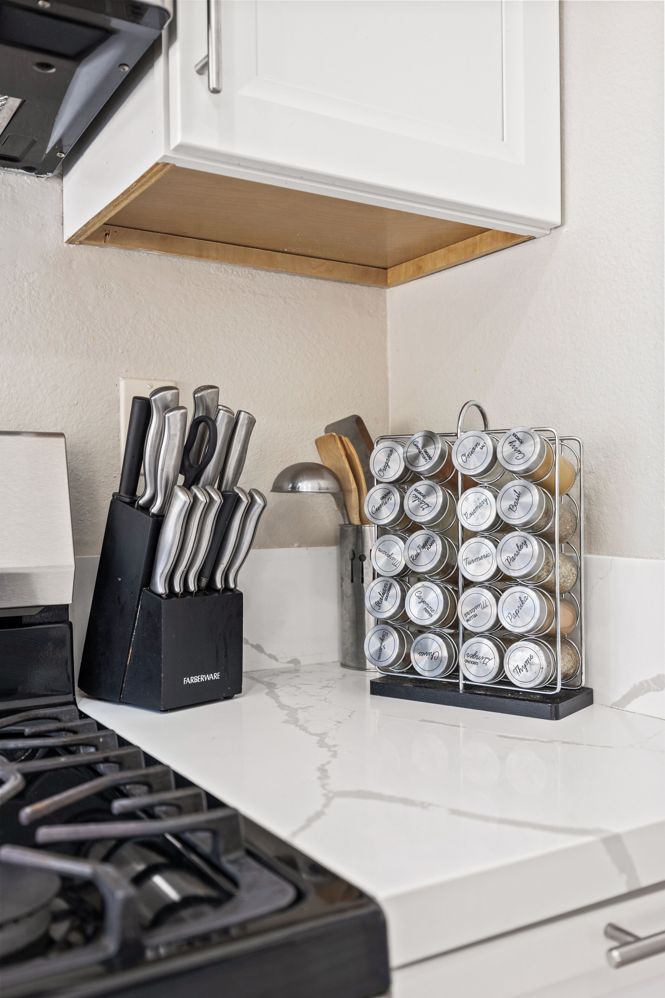 Una encimera de cocina con un bloque de cuchillos y un especiero.